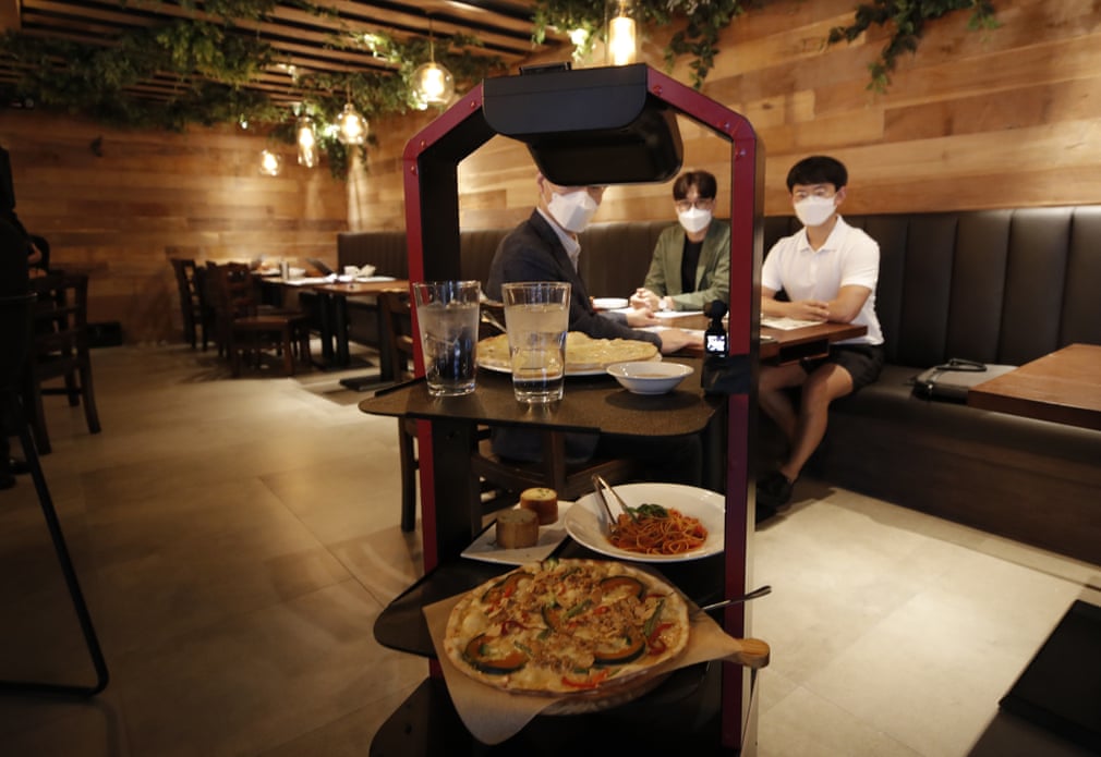 Janubiy Koreyaning Seul shahridagi restoranda ovqat va ichimlik tarqatayotgan robot.