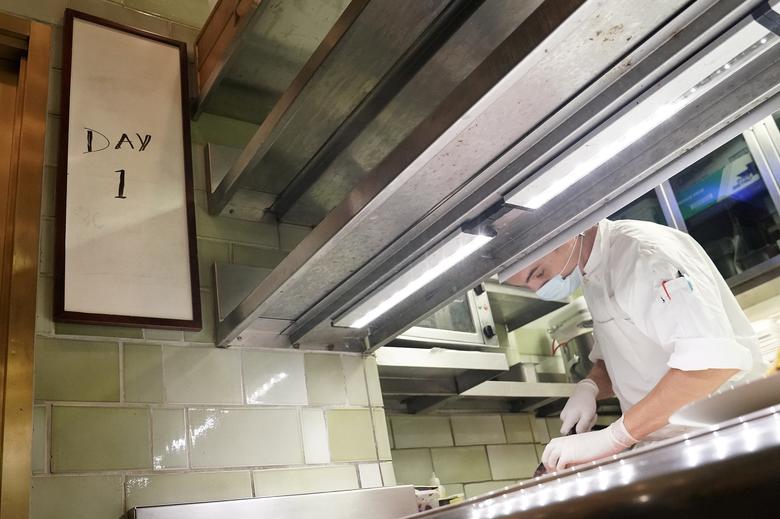 Нью-Йоркда ресторанларга фаолиятини қайта тиклашга рухсат берилган биринчи куни овқат тайёрлаётган ошпаз.