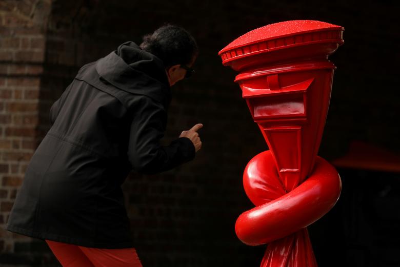 London shahridagi KCAW20 Public Art Trail ko‘rgazmasi uchun hozirlangan haykalga qarab turgan ayol.