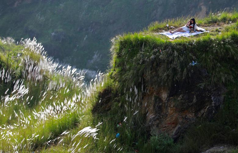 Nepallik ayol Katmandudagi piknik uchun mo‘ljallangan joyda kitob o‘qimoqda.