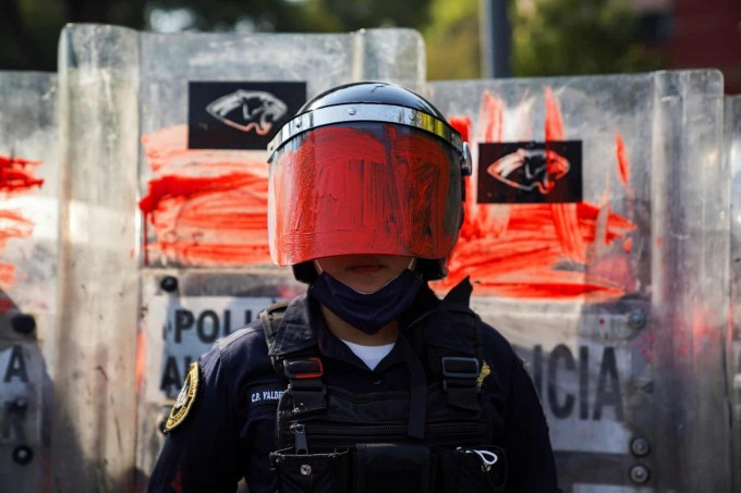 Мексиканинг Мехико шаҳридаги қийноққа қарши намойишда шлеми намойишчилар томонидан бўялган полициячи.