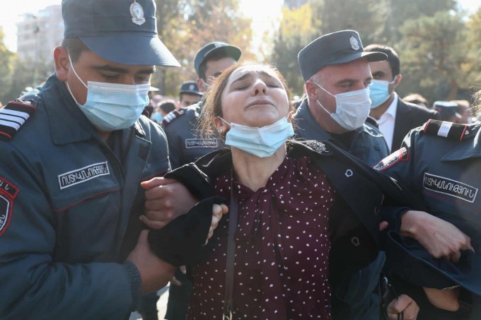 Armanistonning Yerevan shahrida politsiya xodimlari hukumatning Tog‘li Qorabog‘ masalasidagi sulhiga qarshi chiqqan namoyishchi ayolni olib ketmoqda.