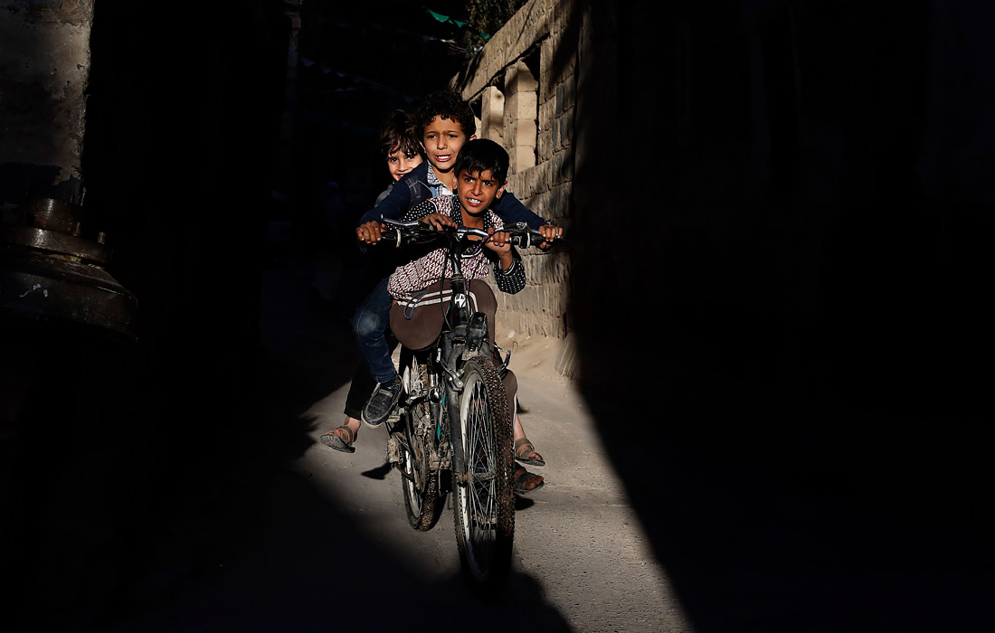 Yamanning Sana shahrida eski shahar hududida velosipedda uchib yurgan bolalar.