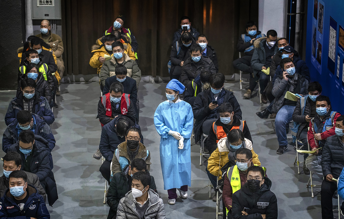 Пекин шаҳрида Sinopharm компаниясининг коронавирусга қарши вакцинасини олиш учун навбатда турган одамлар.