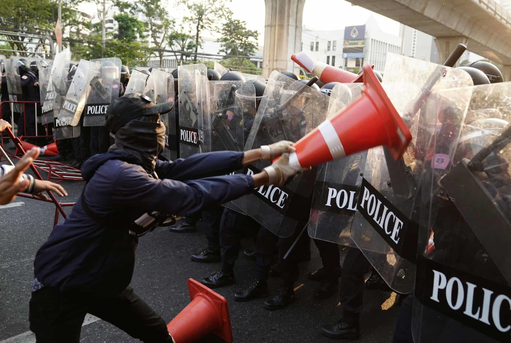 Tailandning Bangkok shahridagi Myanma elchixonasining binosi oldida Myanmada demokratiya tamoyillarini targ‘ib qilish tarafdorlardan biri yo‘l konusi bilan politsiya vakiliga qarshilik ko‘rsatmoqda.