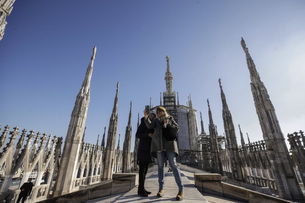 Италиянинг Милан шаҳрида локдаундан сўнг қайта очилган Duomo кафедрал собори томида селфи қилаётган ташриф буюрувчилар.