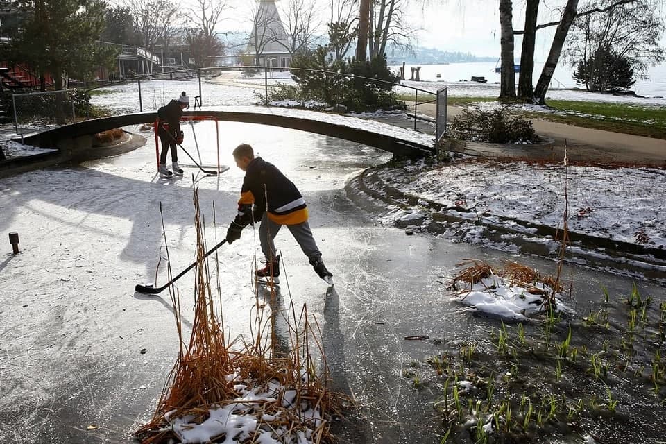 Швейцариянинг Цюрих шаҳридаги музлаб қолган дарё устида хоккей ўйнаётган болалар.