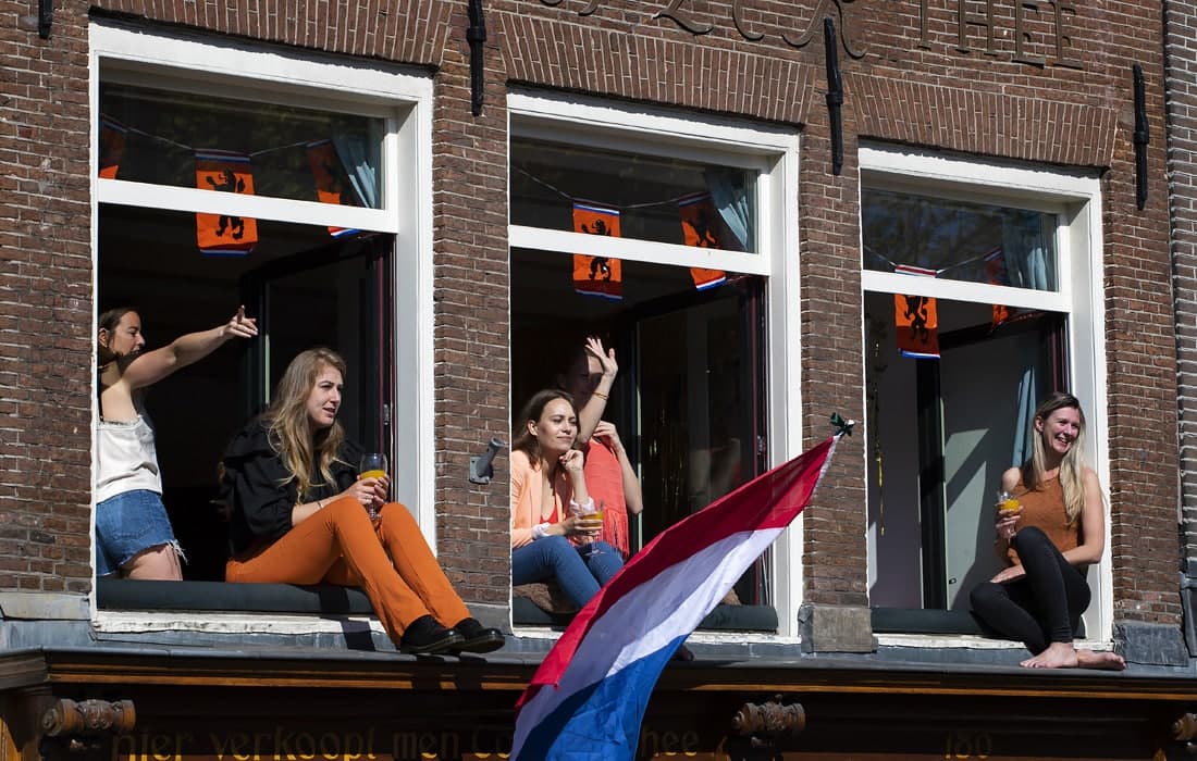 Amsterdamda milliy bayram — Niderlandiya Qiroli kuni nishonlandi. Suratda ko‘chada bo‘layotgan shodiyonalarni derazadan kuzatayotgan qizlar.
