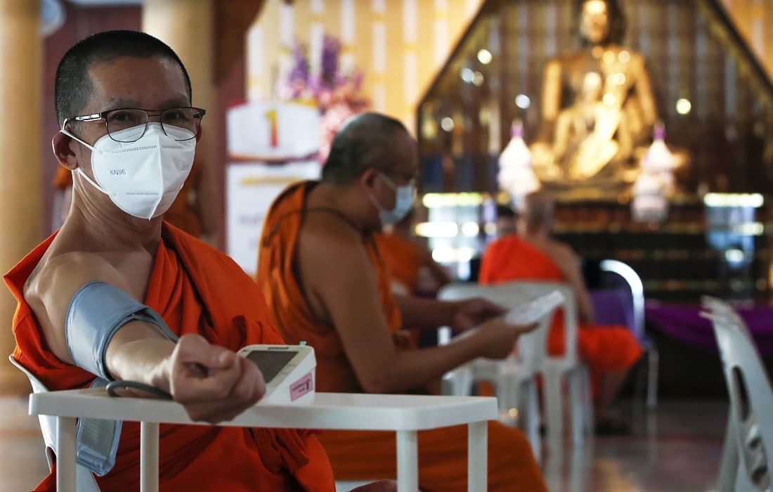 Bangkokda AstraZeneca bilan COVID-19’ga qarshi emlanishdan oldin qon bosimini o‘lchatayotgan buddist monaxlar.