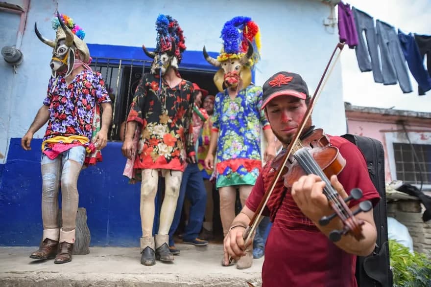 Meksika aholisi an’anaviy karnavalni nishonlamoqda. Festivalda bir guruh odamlar niqoblangan holda ko‘chalarda raqsga tushadi.