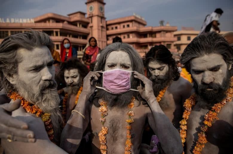 Hindistonning Xaridvar shahrida o‘tkazilayotgan ko‘zalar festivali doirasida Ganga daryosiga cho‘milish uchun tushib ketayotgan hinduiy niqob kiymoqda.