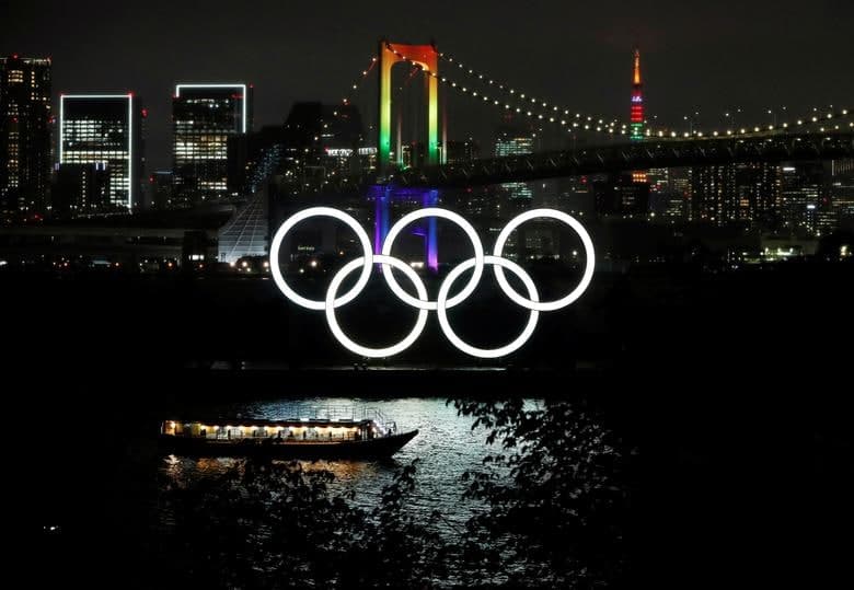 Токиодаги Олимпиада рамзи орқасида кўринаётган камалак рангидаги кўприк ва Токио минораси. Токио—2020 Олимпиадаси бошланишига 99 кун қолди.