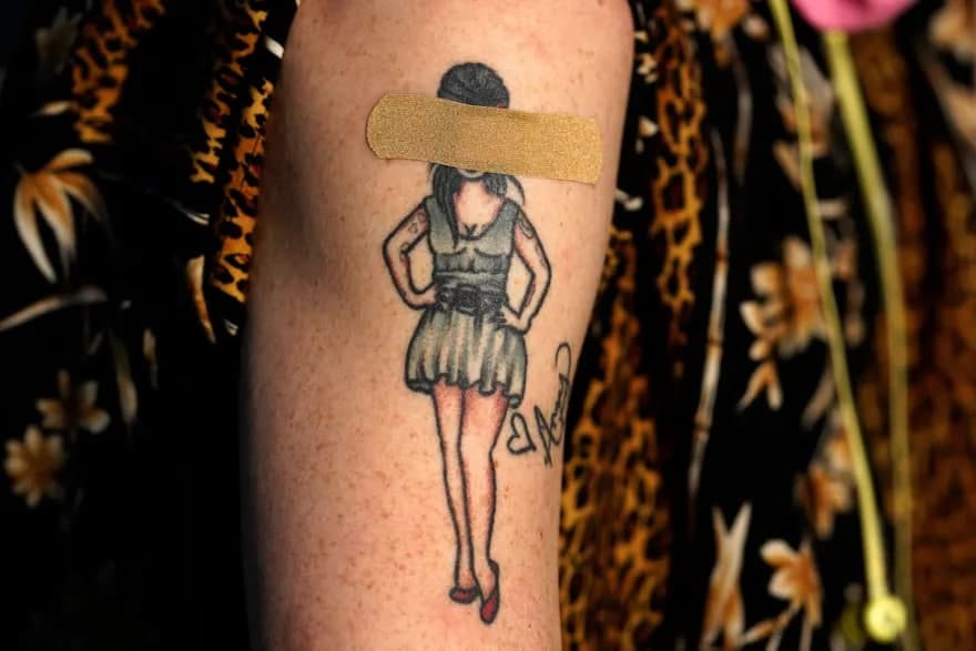 Вашингтонда қўшиқчи Эми Уайнхауснинг татуировкаси бандаж билан қопланган. У «Вакцина олинг — пиво ичинг» эмлаш тадбирида қатнашяпти.
