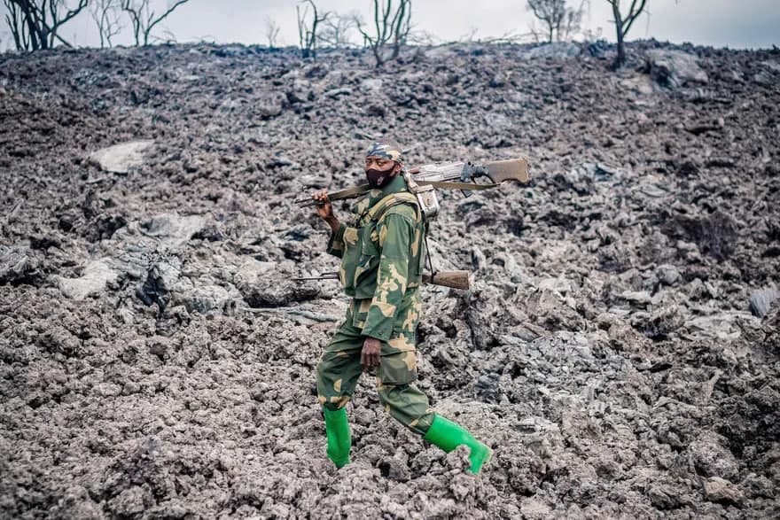 Kongolik askar Nyiragongo vulqoni otilishi natijasida Gomadan evakuatsiya qilingan odamlarning xavfsizligini ta’minlagan holda sovugan lava ustida yurib ketmoqda.