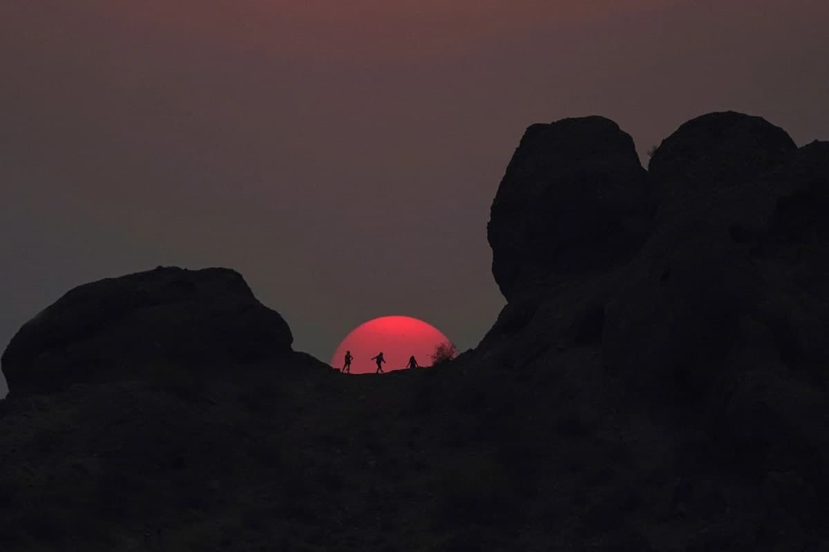 Arizona shtatidagi Papago tabiat bog‘ida quyosh botishini tomosha qilish uchun to‘xtagan sayyohlar.