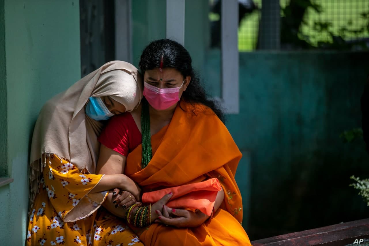 Nogiron nepallik qiz onasi bilan Katmandudagi Nepal nogironlar uyushmasi markazida vaksina olish uchun navbat kutmoqda.
