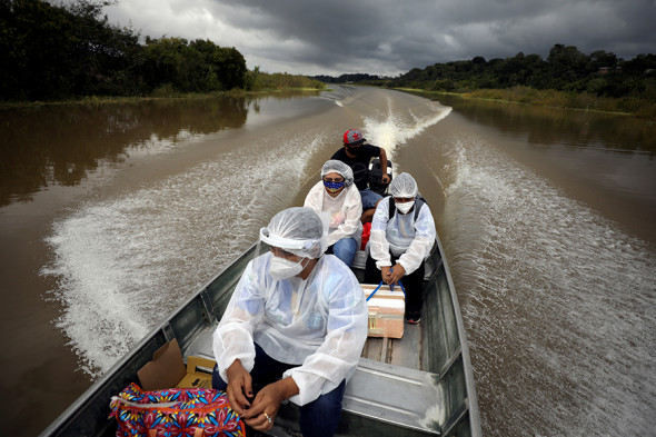 Braziliyaning Amazonas shtati Manakapuru munitsipalitetida tibbiyot xodimlari AstraZeneca vaksinasini Solimoes daryosi orqali olib ketmoqda, 2021-yil 3-fevral.