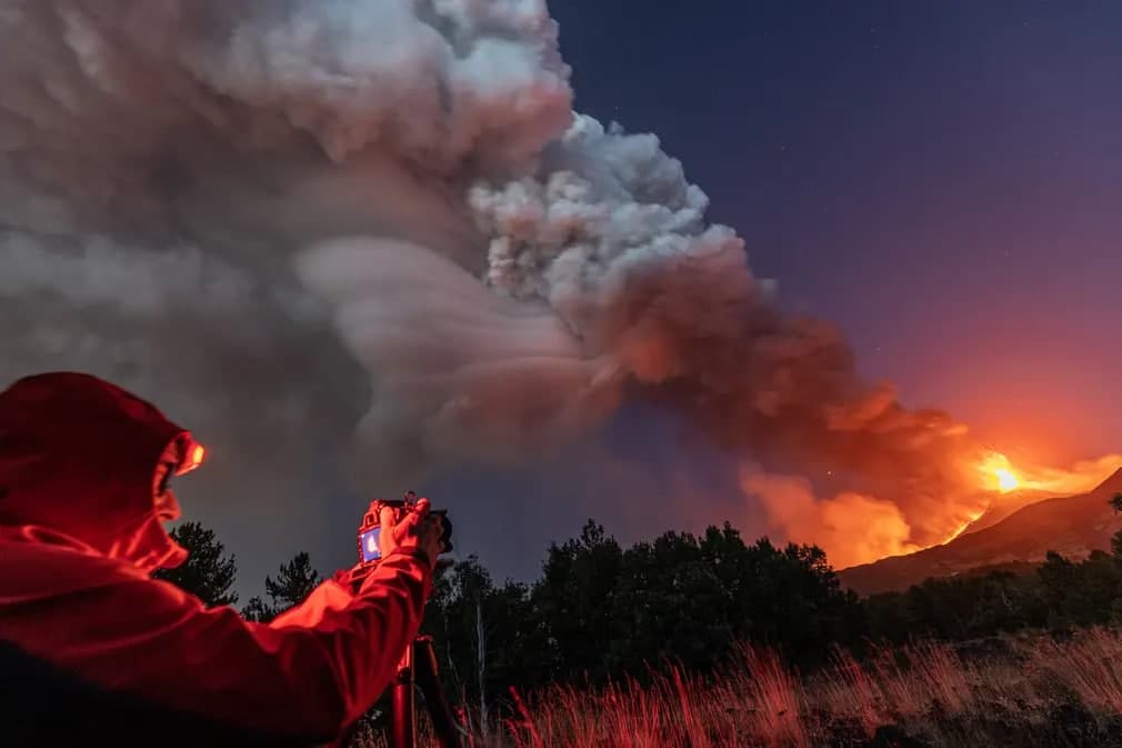 Sitsiliyadagi Etna vulqoni otilishini suratga olayotgan fotosuratchi.