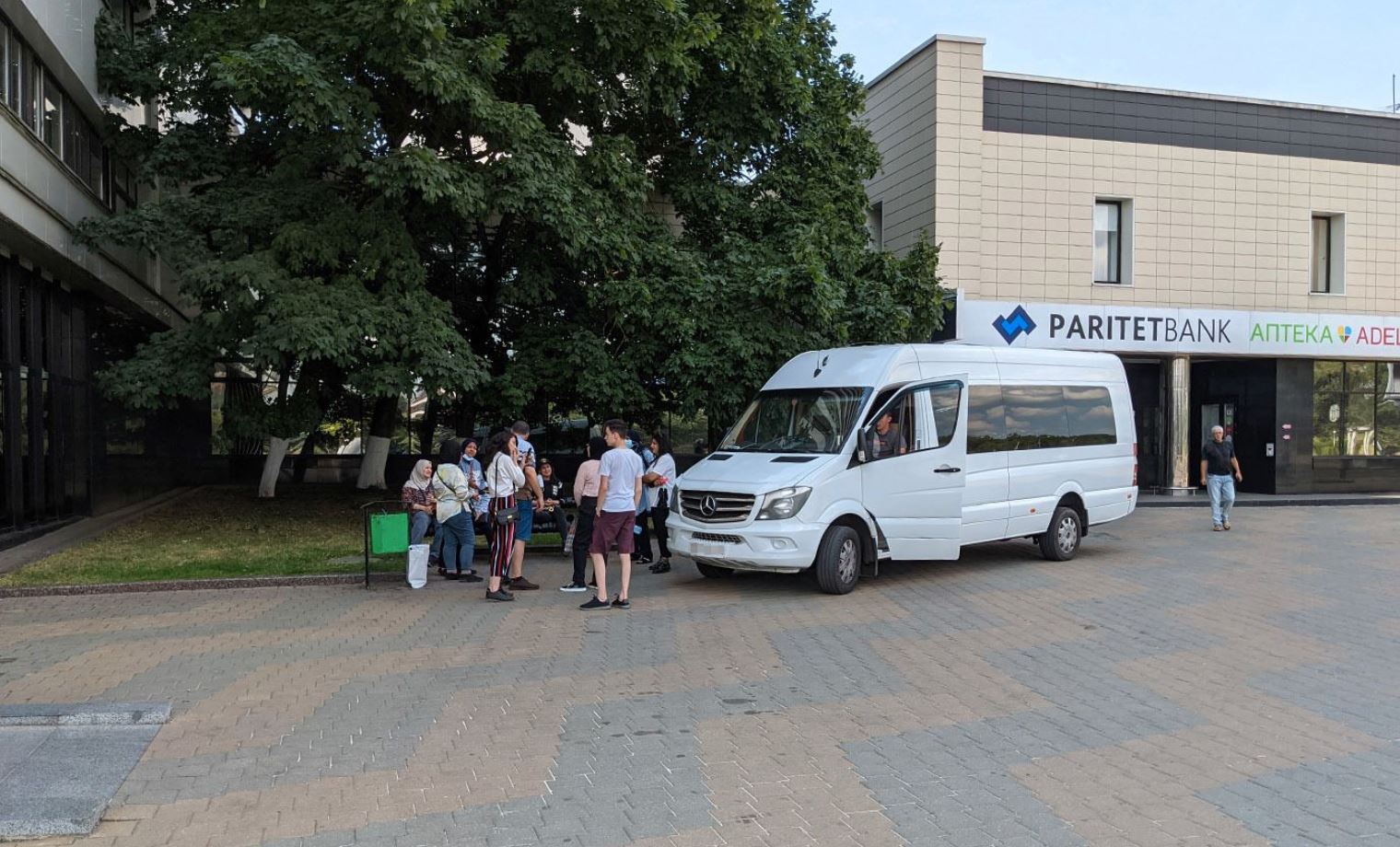 Minskdagi “Yubileynaya” mehmonxonasi oldidagi mikroavtobus va uning yo‘lovchilari.