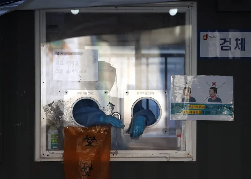 Seul stansiyasi oldidagi koronavirus tahlili uchun odamlardan namuna olishga tayyorgarlik ko‘rayotgan tibbiyot xodimi.