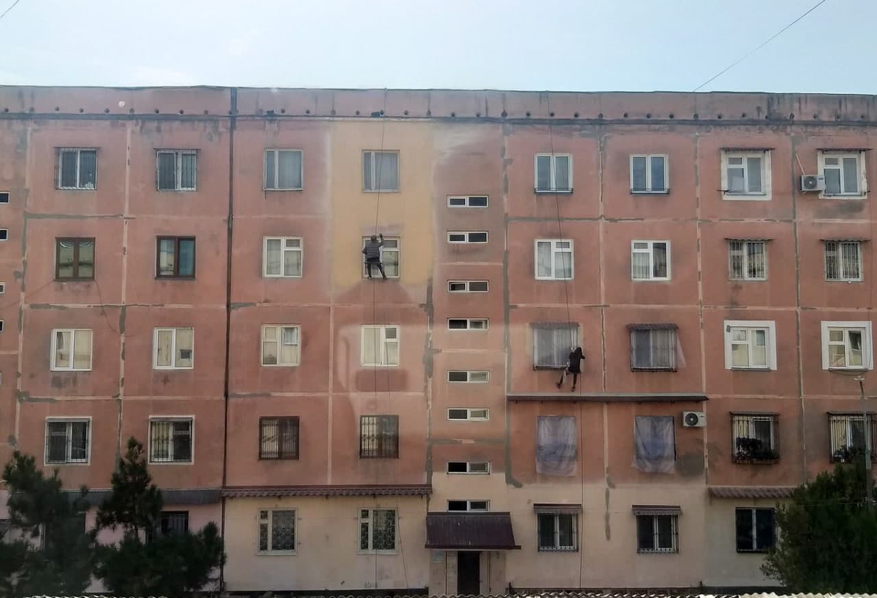 Toshkent shahri, Yunusobod tumanidagi ko‘p qavatli uylardan birining ustki qismini bo‘yab chiqayotgan mahalliy xodimlar.