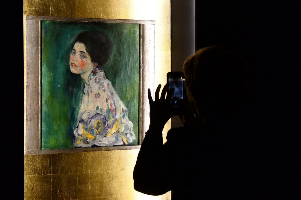Rimdagi Gustav Klimt asarlari ko‘rgazmasiga tashrif buyurgan shaxs avstriyalik rassomning portretini suratga olmoqda.