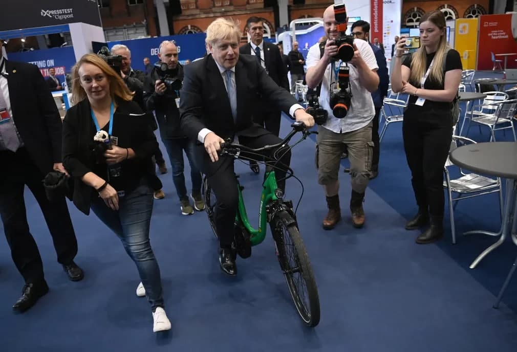 Бош вазир Борис Жонсон Консерватив партиянинг йиллик конференциясида велосипед миниб суратга тушмоқда.