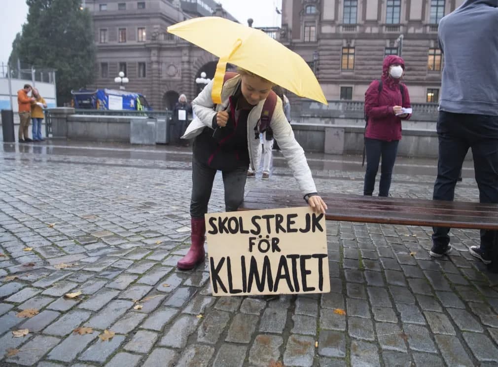 Stokgolmda Greta Tyunberg Riksdag (Shvetsiya parlamenti) tashqarisida iqlim o‘zgarishlaridan ogohlantiruvchi afishani joylashtirmoqda.