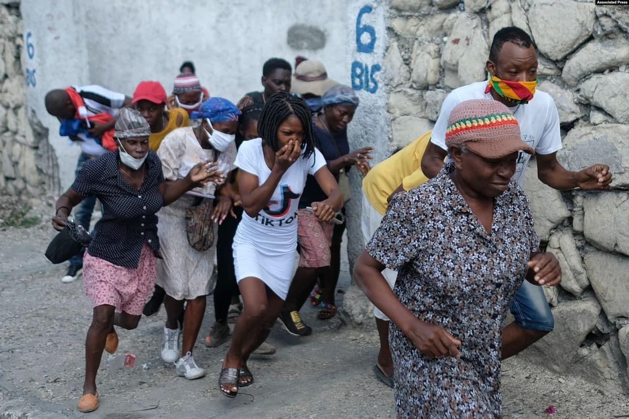 Порт-о-Пренс шаҳрида Гаити президенти Жовенель Моизенинг ўлдирилиши учун адолат талаб қилиб бош вазир қароргоҳига борган одамлар полиция томонидан отилган кўздан ёш оқизувчи газдан қочмоқда.