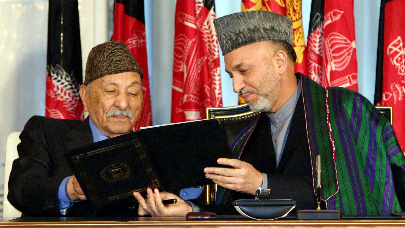 Afg‘oniston prezidenti Hamid Karzay sobiq qirol Zohir Shohga yangi konstitutsiyani ko‘rsatmoqda