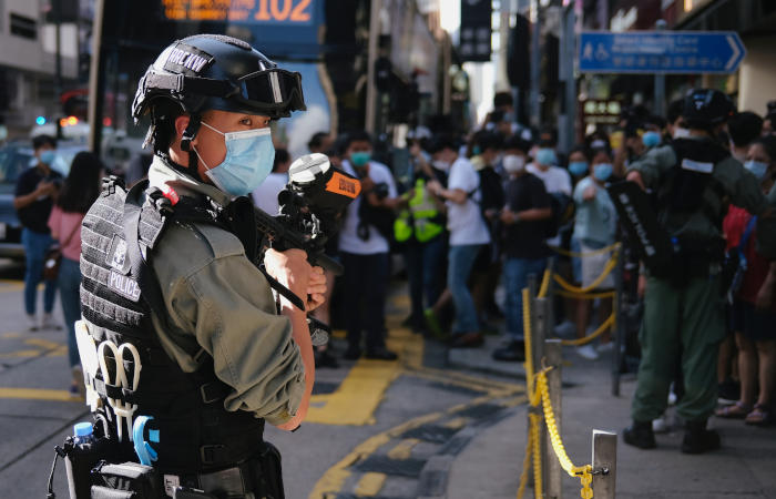 Гонконг кўчасида хавфсизлик тўғрисидаги қонунга норозилик билдираётганларга қарши турган полиция, 2020 йил, июнь.