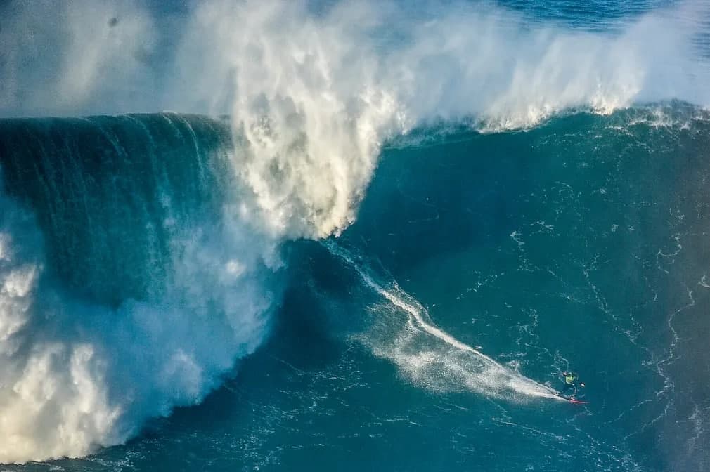 Португалия соҳилидаги Tow Surfing Challenge мусобақасида қатнашаётган сёрфингчи. Бу ҳудуд дунёдаги энг катта тўлқинларни келтириб чиқариши билан машҳур.