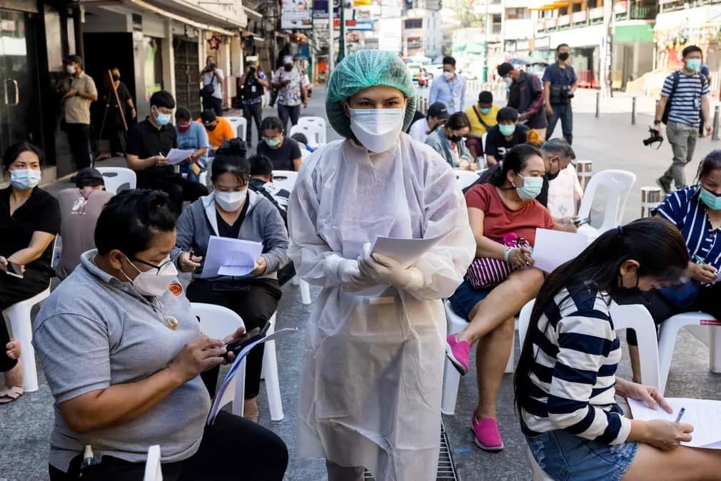 Turizm xodimlarini Bangkokdagi koronavirus test markazida ro‘yxatdan o‘tkazayotgan shifokor.