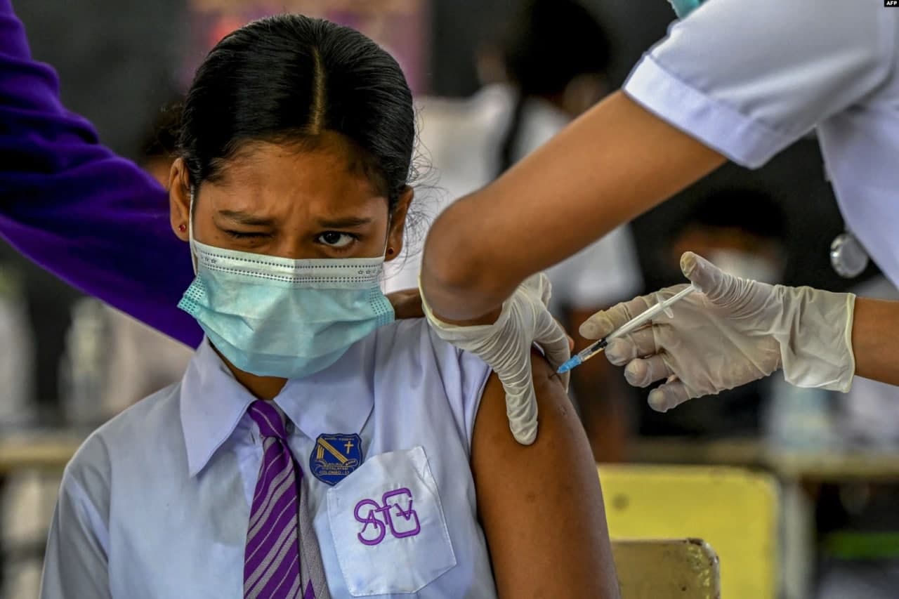 Шри-Ланканинг Коломбо шаҳридаги таълим муассасасида коронавирусга қарши Pfizer-BioNTech вакцинаси билан эмланаётган талаба.