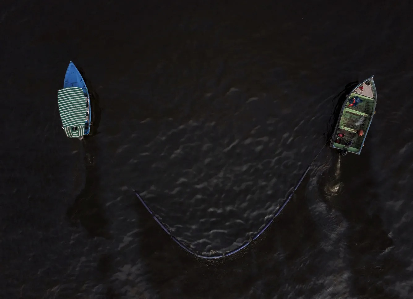 Анкон курорт шаҳридаги пляжда қайиқлар денгиз сатҳидаги нефтни йиғиб олмоқда, Шимолий Лима, 2022 йил 20 январь