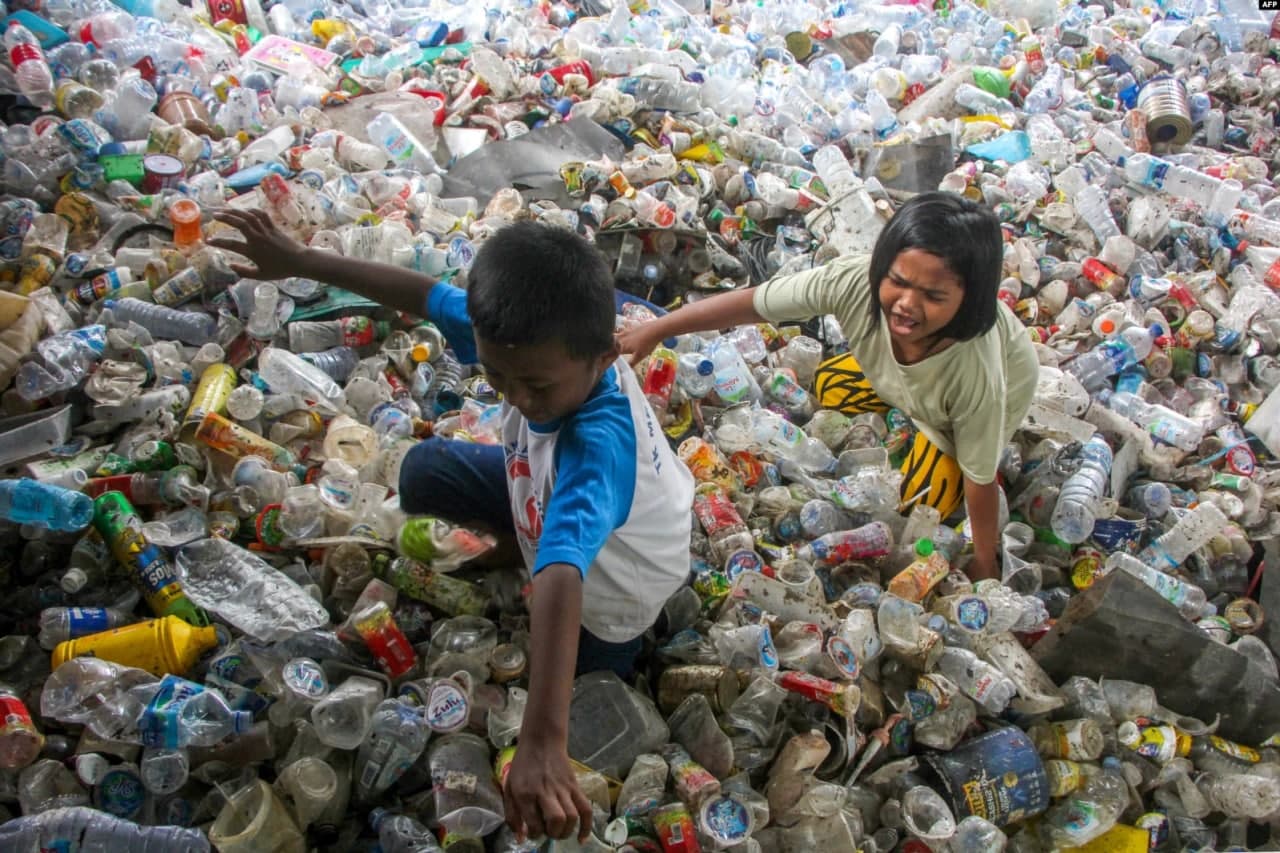 Indoneziyaning Makassar shahrida bolalar qayta ishlash uchun yig‘ilgan plastik chiqindilar uyumi ustida o‘ynamoqda.