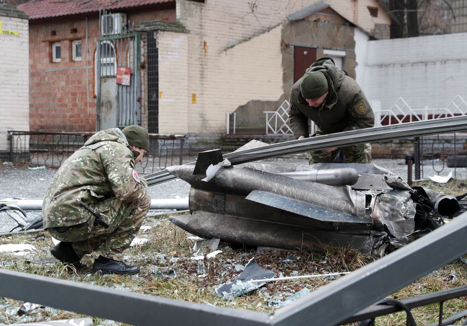Полиция ходимлари Киев кўчаларидан бирига қулаган ракета қолдиқларини текширмоқда.