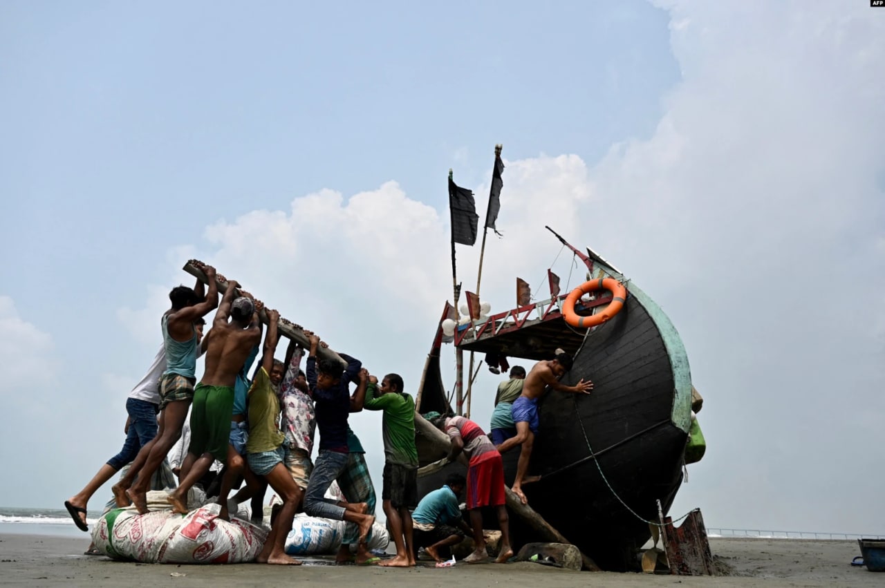 Bangladeshning Teknaf shahrida Bengal ko‘rfazidan baliq ovlagan baliqchilar sohilga chiqib qolgan qayiqni ko‘tarmoqda.