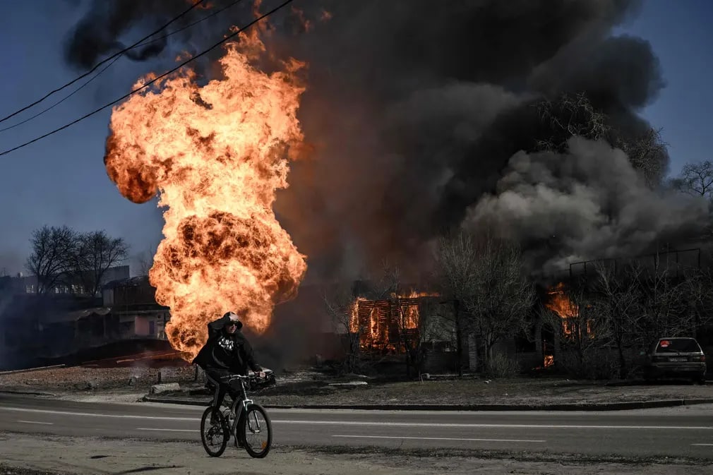 Rossiyaning Ukrainadagi harbiy harakati boshlanganining 30-kuni. Suratda: Yong‘in sodir bo‘lgan joy yaqinidan o‘tayotgan velosipedchi.