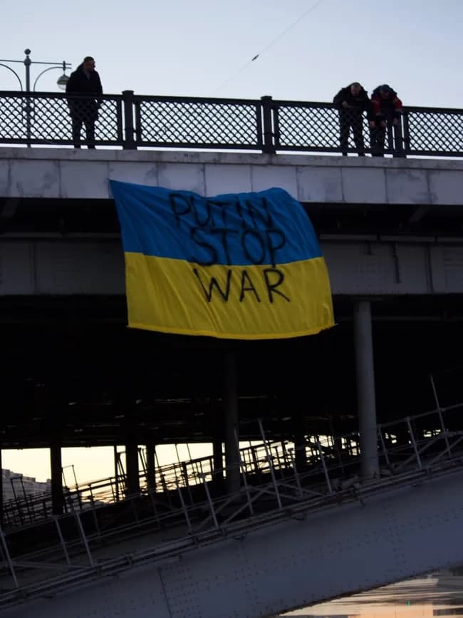 Moskvadagi ko‘prikka ilingan Ukraina bayrog‘i. Unga “Putin urushni to‘xtat” deb yozilgan