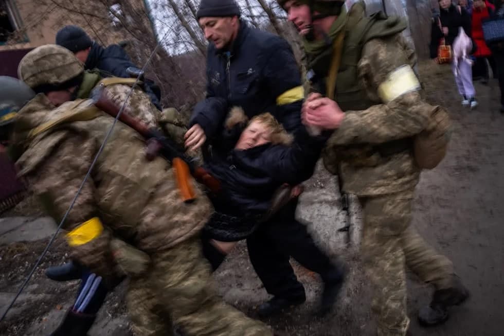 Украина ҳарбийлари аҳолини эвакуация қилиш чоғида кекса аёлни Ирпен дарёсидан олиб ўтмоқда