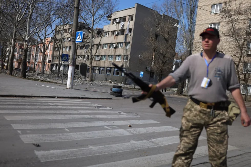 Ukrainalik askar Kiyevdagi vayron bo‘lgan uy yonida