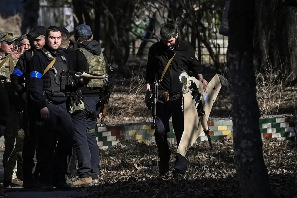 Urib tushirilgan Rossiya dronini ko‘tarib olgan ukrainalik askar. Kiyev