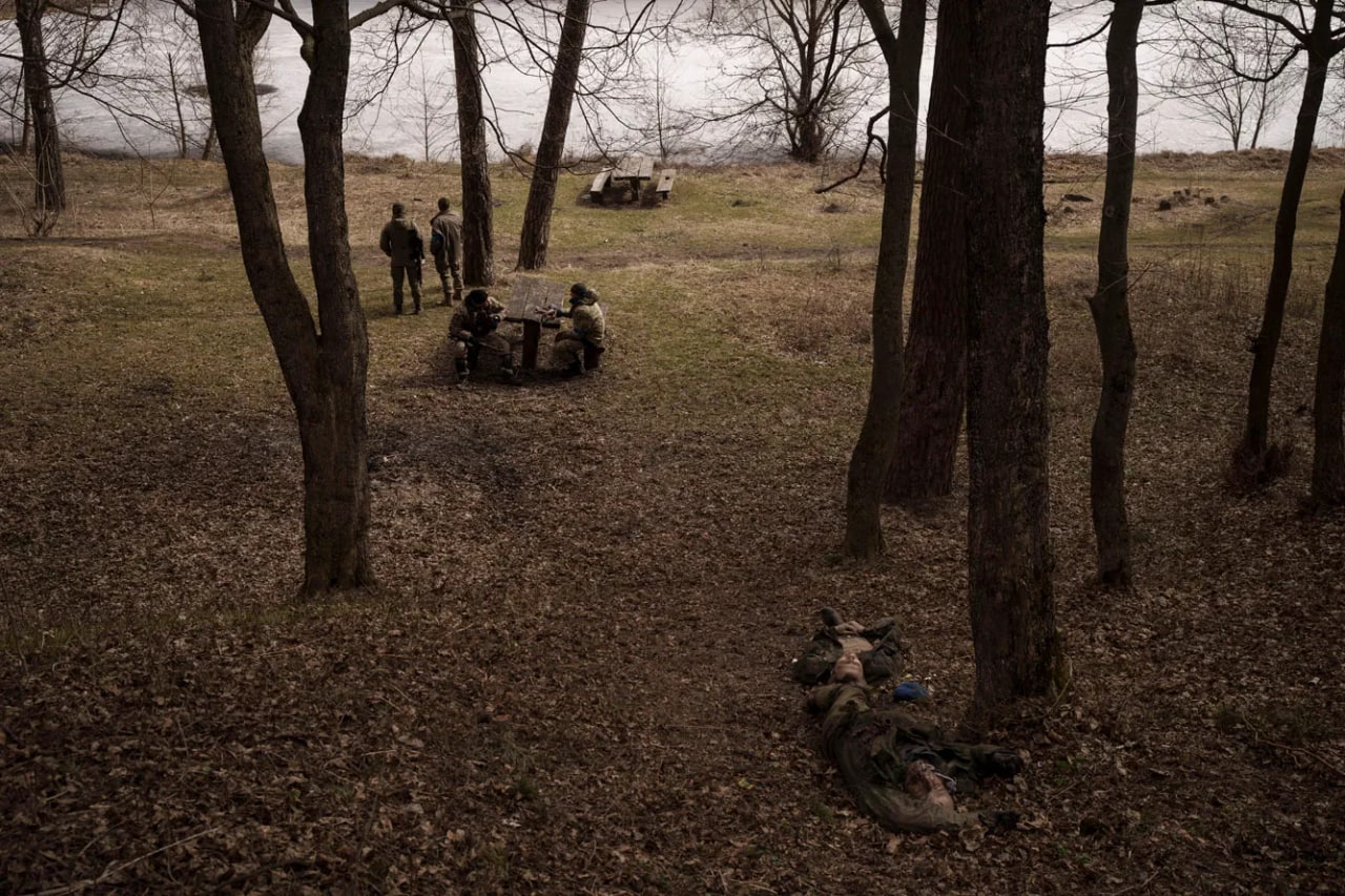 Ukrainalik askarlar va ular yaqinida yotgan rossiyalik harbiylarning jasadlari. Trostyanets, 2022-yil 28-mart