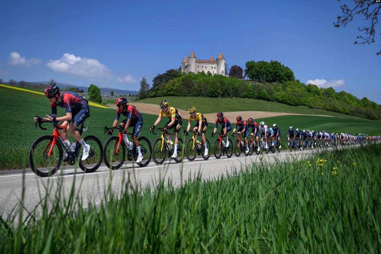 UCI World Tour velopoygasining birinchi bosqichida Champvent qal’asi yonidan o‘tib ketayotgan sportchilar, Shveysariya.