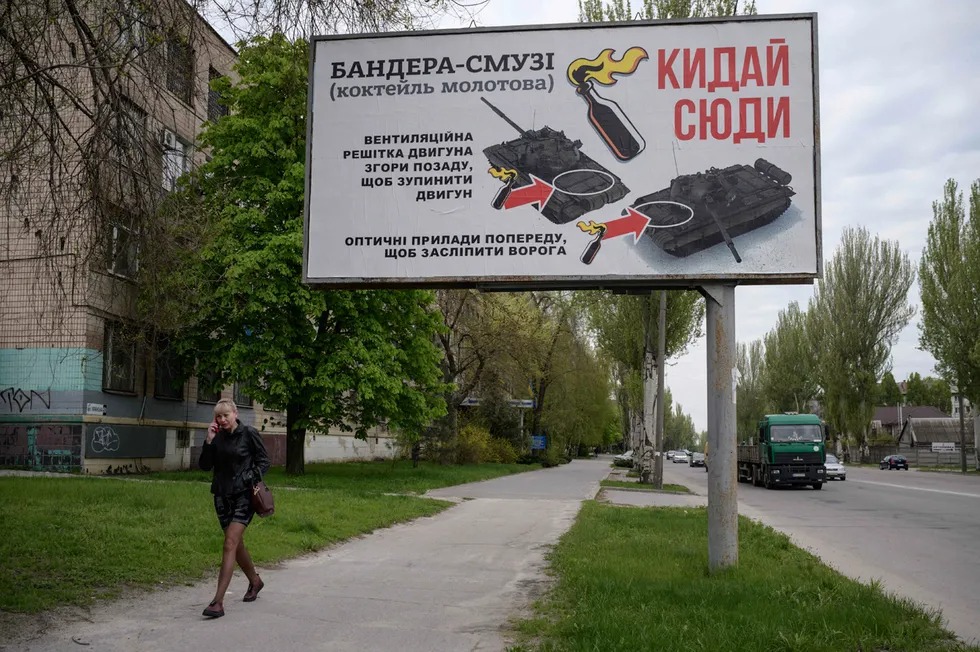 Molotov kokteyli qo‘lbola portlash vositasini Rossiya tankiga qanday otish kerakligi tushuntirilgan banner.