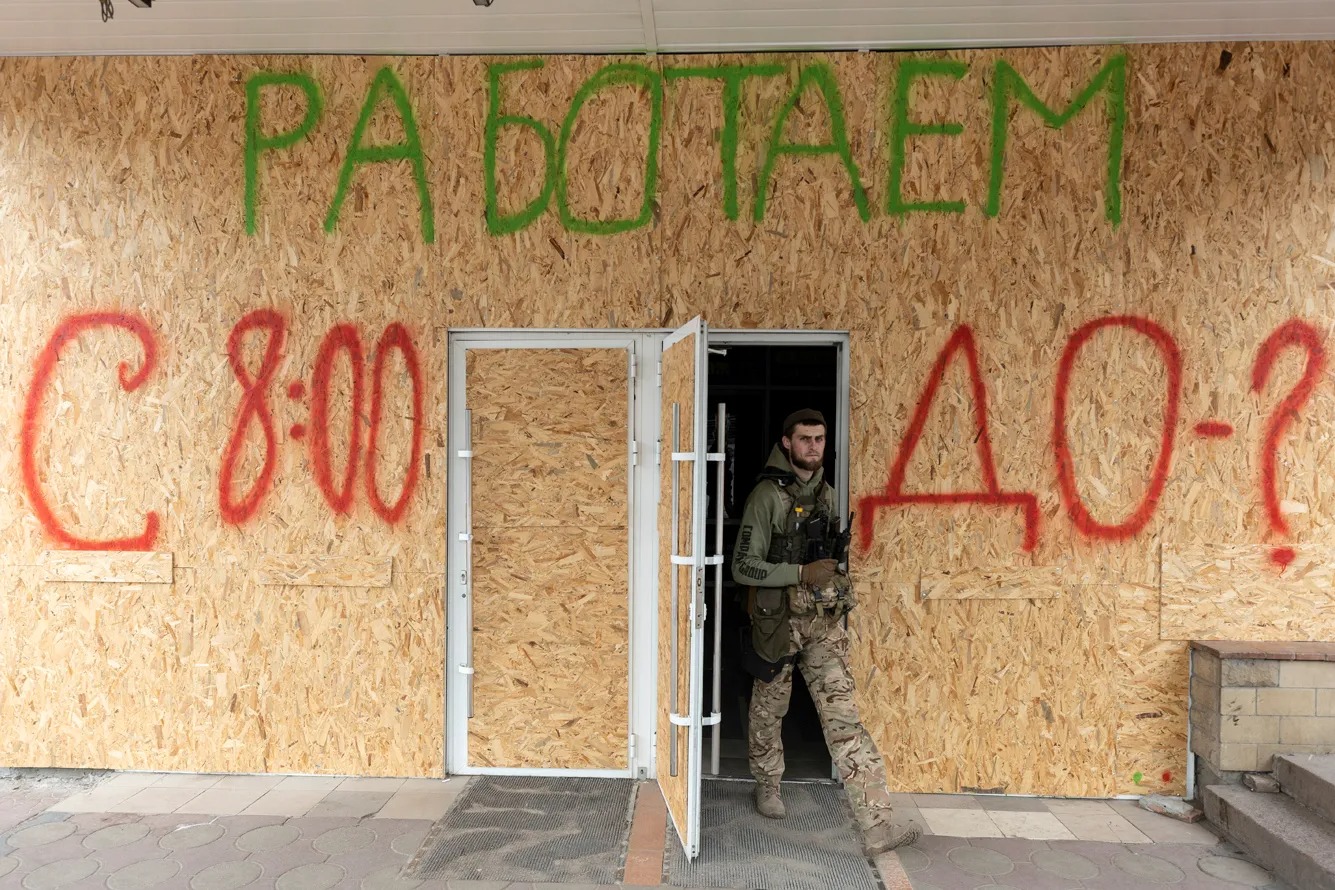 Ukraina askari Kramatorskdagi savdo markazidan chiqmoqda.