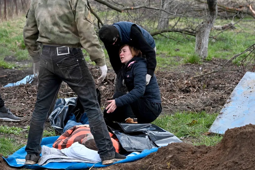 O‘ldirilgan turmush o‘rtog‘ining shaxsini tasdiqlayotgan ayol. Erkakning jasadi Kiyev viloyati, Andreyevka qishlog‘idagi uylardan uzoq bo‘lmagan vaqtinchalik qabrga dafn qilindi.