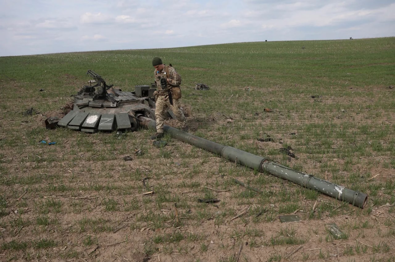 Portlatib yo‘q qilingan Rossiya tanki minorasi yonidagi ukrainalik askar.