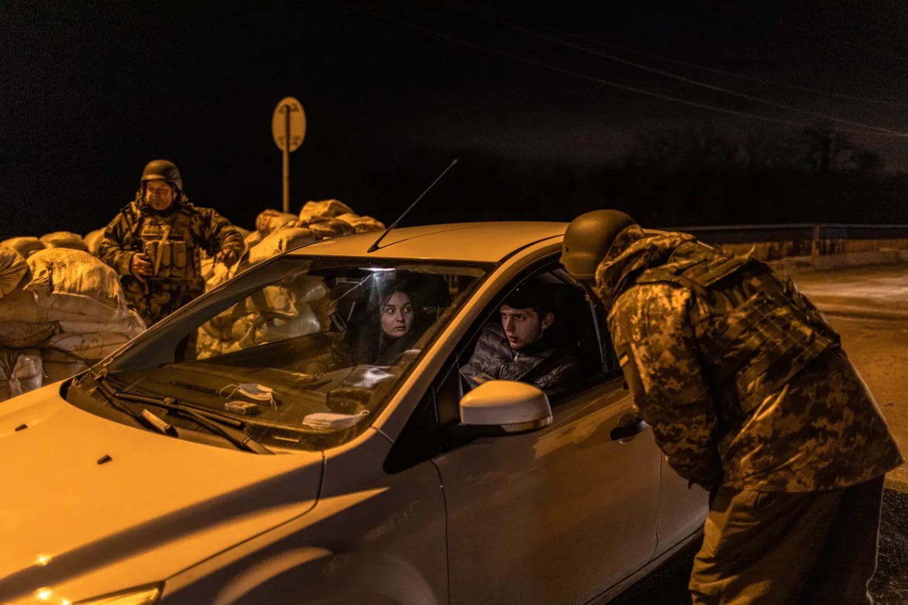 Hududiy mudofaa xizmatchilari mashinadagi odamlarni nazoratdan o‘tkazmoqda. Kiyev viloyatining sharqiy front chizig‘idagi blokpost.